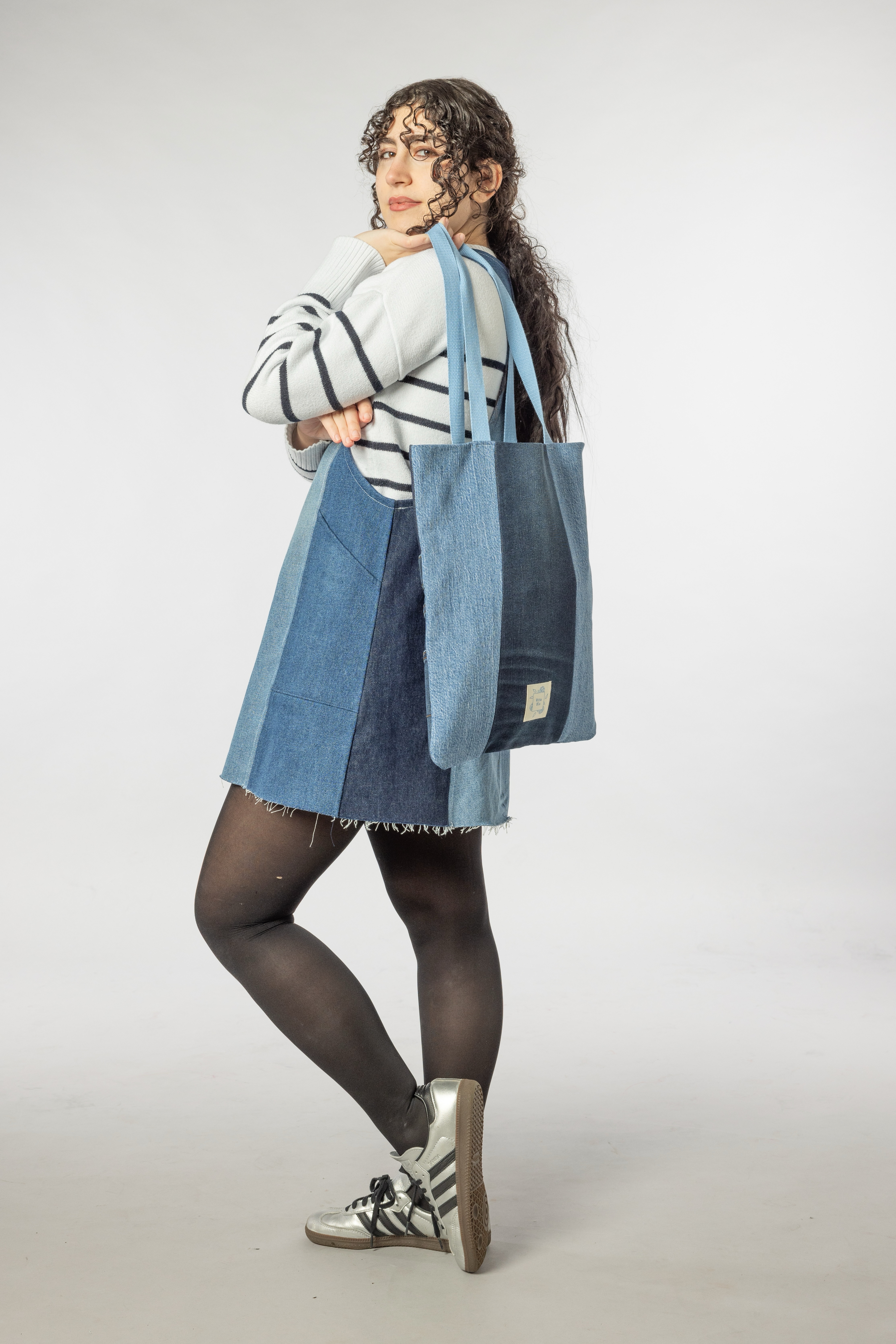 A female model having an Atlas tote bag on her shoulder.